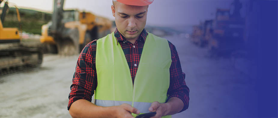 Man in a construction vest on his phone.